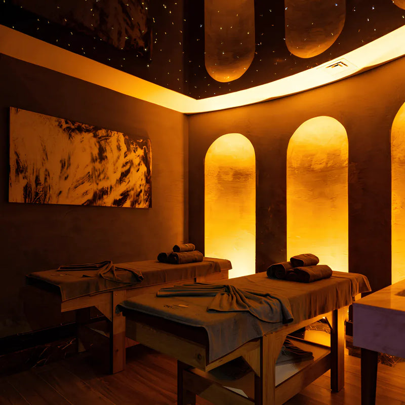 Modern wellness spa treatment room with massage tables and ambient lighting for relaxation and recovery.