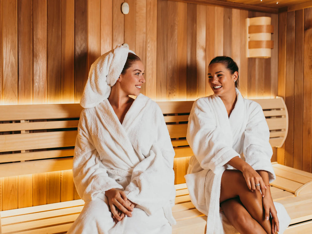 Two people relaxing inside a modern 2-person indoor sauna.