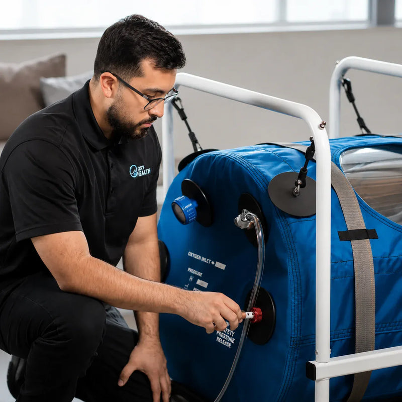 OxyHealth technician preparing a portable hyperbaric oxygen therapy (HBOT) chamber for treatment.