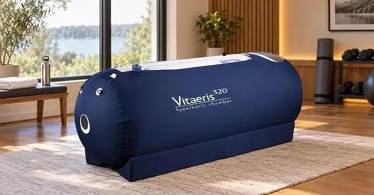The OxyHealth Vitaeris 320® hyperbaric chamber, popular for home HBOT for athletes, on a rug in a sunlit home recovery room, dumbbells behind it.