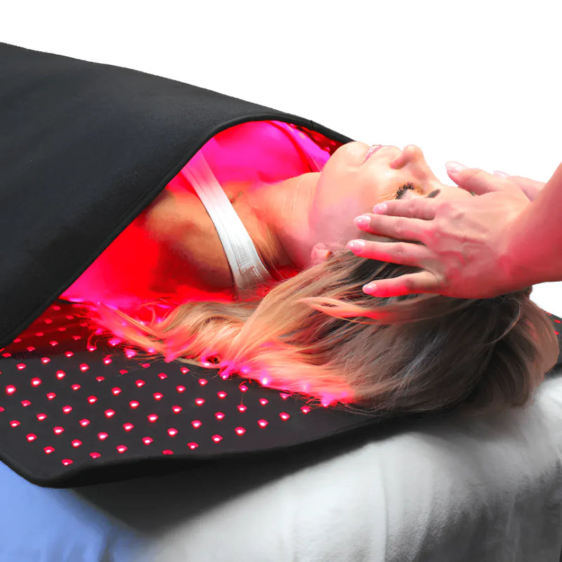 Person receiving red light therapy on a full-body LED light therapy mat during a wellness session.